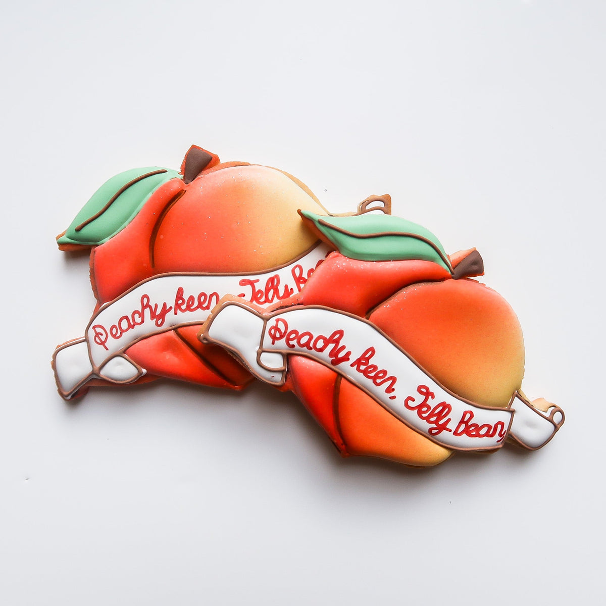 Peach-shaped sugar cookies with hand-piped lettering by Reet Petite Bakery Co