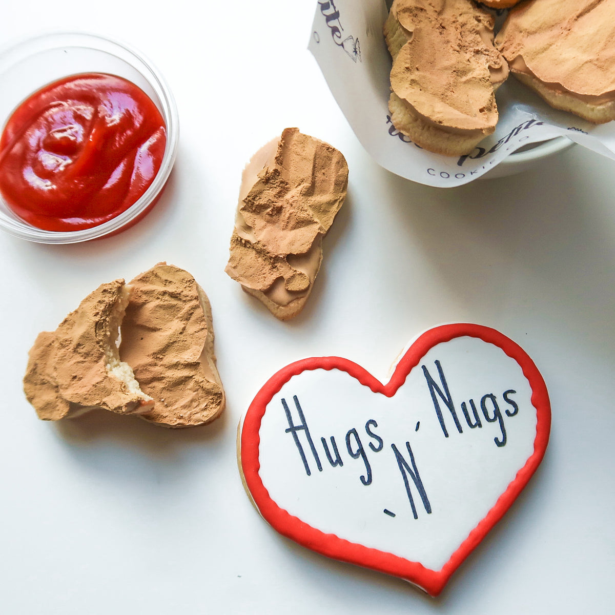 Close-up of hand-decorated Hugs N Nugs heart and nugget sugar cookies