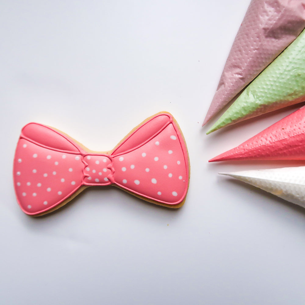 Pink polka-dot bow sugar cookie and icing bags