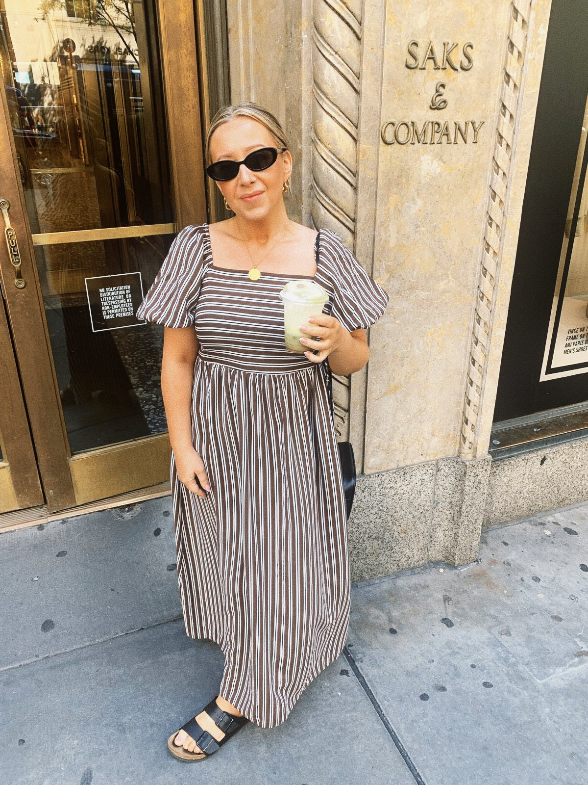 Samantha, founder of Reet Petite Bakery Co, wearing a striped dress and sunglasses outside a shop.